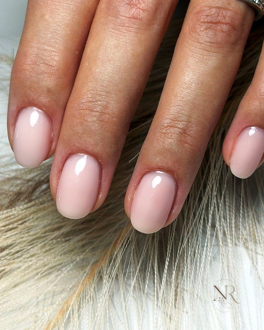 Unghie corte ovali con semipermanente rosa latte lucido